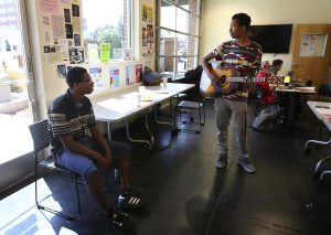 Isaiah Mosley listens to Dvarius Williams play music at the Dream Center in downtown Bakersfield. Henry A. Barrios / The Californian